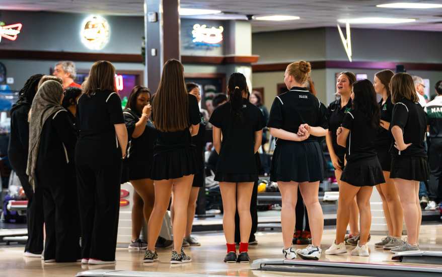 Girls bowling team in a huddle